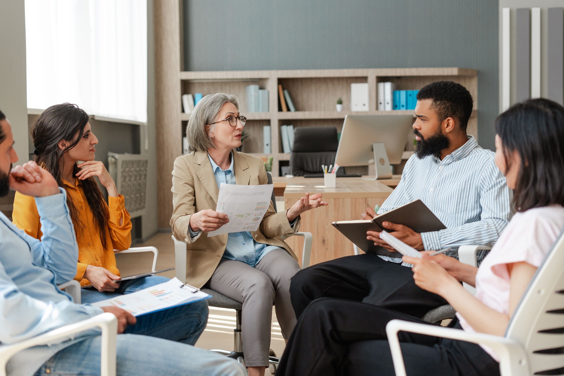 Senior businesswoman leading brainstorming session with her team in modern office. Teamwork concept